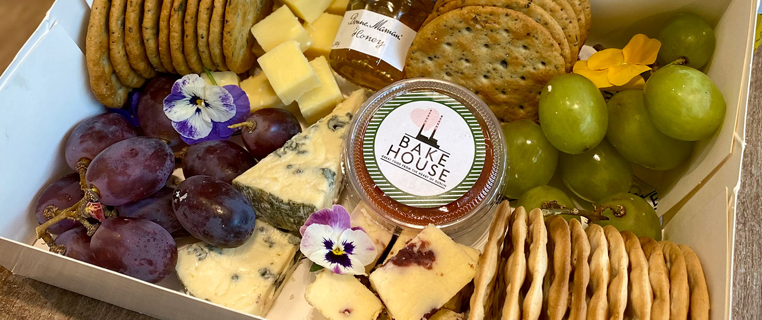 Cheese Grazing Box Including: Cashel blue, Hegartys cheddar, Cheese special (changes), Bonne Mamon honey pot, Bakehouse relish, 2 x cracker selection, Green &; black grapes