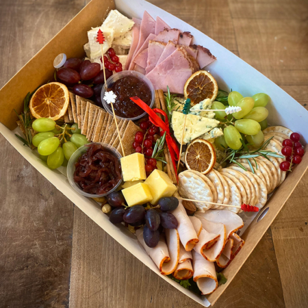 A selection of cheese and meats in ready for a Chrismas party